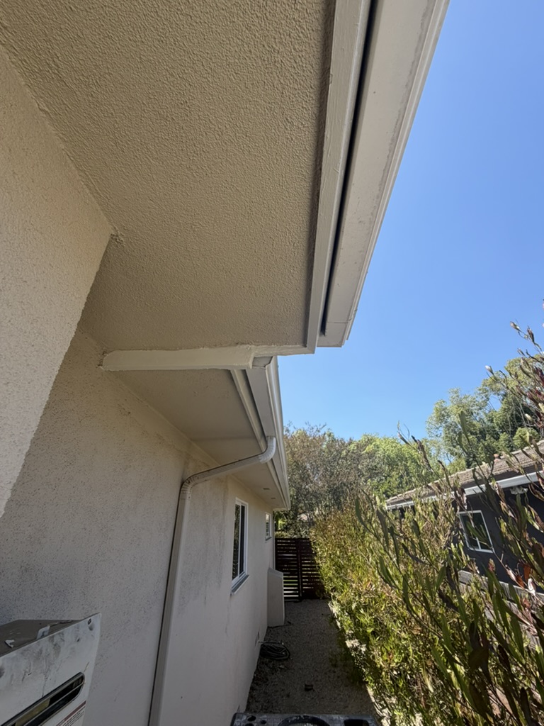 Repainted fascia board and gutter corner after repair